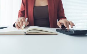 Kobieta zapisująca obliczenia w księdze