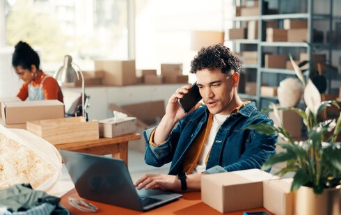 Młody przedsiębiorca rozmawia przez telefon w sprawie finansowania w modelu revenue based financing