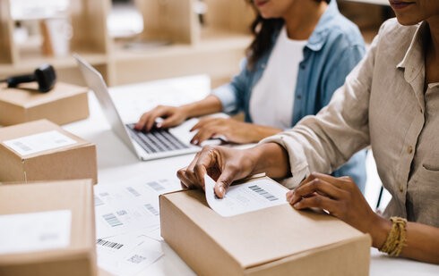 osoby pracujące na magazynie pakują zamówienie w ramach dropshippingu