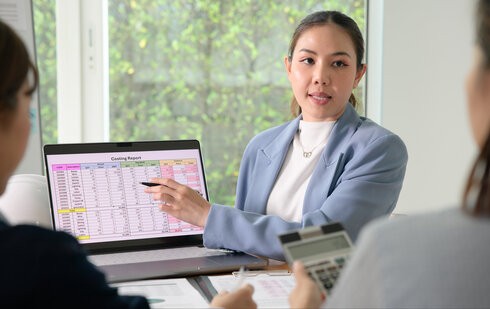 księgowa prezentuje wyliczenia dotyczące faktoringu i kosztów uzyskania przychodów klientkom