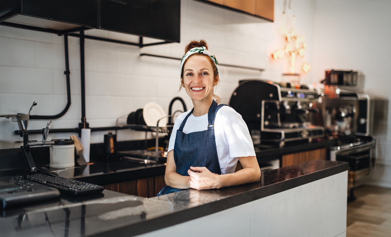 A café owner at the counter with a payment terminal – payment platforms and terminal operators