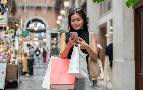 klientka korzysta z rozwiązań omnichannel – sprawdza promocje w telefonie podczas zakupów
